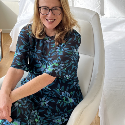 Nicky Pellegrino sitting on a white armchair