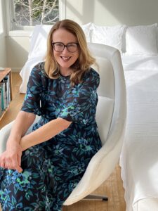 Nicky seated on a white armchair.